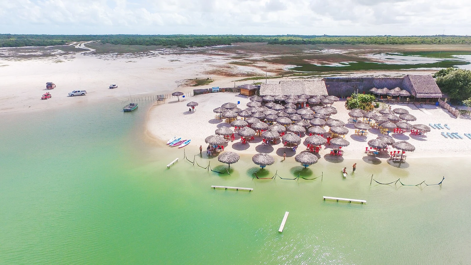 Vista aérea da Lagoa Azul, com barracas na areia branca, casa em Jericoacoara